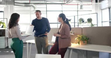 İspanyol kadın ofise giriyor ve dizüstü bilgisayarı açıyor, güncelleme için elinde tablet bulunan ekiple veri paylaşıyor. İşbirliği, takım çalışması, modernlik, kurumsal, profesyonel, iletişim, teknoloji