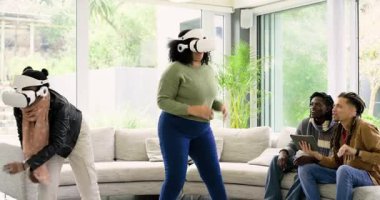 VR kulaklıklarına güç veren çeşitli arkadaşlar oturma odasında erkeklerin tablet rehberliğini takip ederek kollarını hareket ettiriyorlar. Fütürist, sürükleyici, boş zaman, teknoloji, sosyal, çağdaş, yenilik