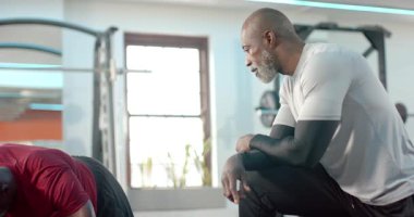 Afrika kökenli Amerikalı antrenör, müşterilerine çekirdek gücü için pencerelerden dağcılara rehberlik ediyor. Fitness, antrenman, güç, egzersiz, spor, koçluk, spor