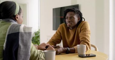 Şöminenin önünde el ele tutuşan Afro-Amerikan çift, rahatlamak için samimi konuşmalar yapıyor. Romantizm, samimiyet, rahatlık, bağlantı, sıcaklık, iletişim, yaşam tarzı