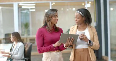 Hintli ve Afrikalı Amerikalı iş arkadaşları güvertede geri bildirim paylaşıyorlar. İşbirliği, yenilik, takım çalışması, profesyonel, modern, iletişim, dijital