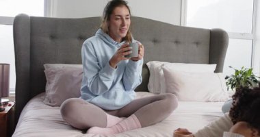 Anne bardak kaldırıyor ve çocuk bardak kaldırıyor sohbet ederken pencerenin yanındaki yatakta el kol hareketi yapıyor. Samimi, şefkatli, evcil, samimi, içten, huzurlu, yaşam tarzı