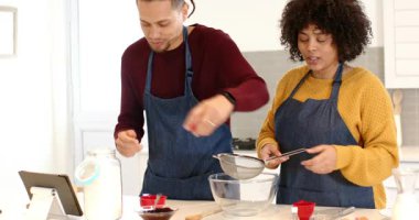 Çift, mutfak tezgahında elek içine şeker ve un koymak için tablet pişirmeye başlıyor. Aşçılık, aşçılık, takım çalışması, modern mutfak, tarif, hazırlık, yaşam tarzı