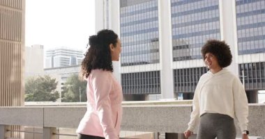 Bayan arkadaşlar omuz esnetmeden önce el sıkışarak ve terasta sohbet ederek selamlaşıyorlar. Açık hava, arkadaşlık, fitness, şehir, sağlık, aktivite, bağlantı