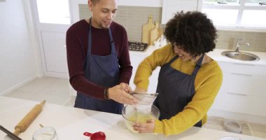 Kadın hamuru kepçelediğinde, bir çift un seçiyor mutfak adasında kek hamuru hazırlıyor. İşbirliği, yerli, samimi, aşçı, takım çalışması, yaşam tarzı, minimalist