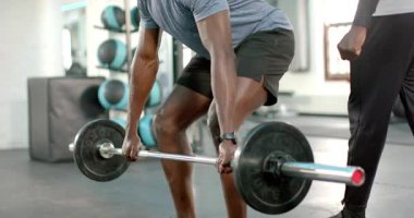 Eğitmen rehberliği ile, Afrikalı Amerikalı müşteri spor salonunda ağırlık kaldırmak için halter kaldırıyor. Güç, zindelik, antrenman, spor, egzersiz, dayanıklılık, güç.