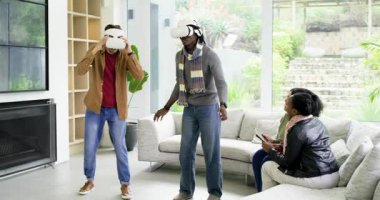 VR oyunu başladığında, çeşitli erkek arkadaşlar kulaklıkları ayarlıyor ve evdeki engelleri aşıyorlar. Fütürist, sürükleyici, boş zaman, sosyal, iç mekan, oyuncu, dinamik