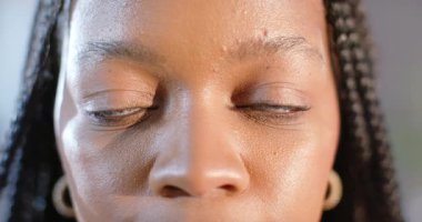 Küpe takan Afro-Amerikalı bir kadın sırıtışını ve mankenlik çekimi için gülümsemesini gösteriyor. Portre, güzellik, zarafet, özgüven, cazibe, dışavurum, tek renk