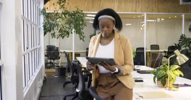 Ofisteki pencereye doğru yürürken Afrikalı Amerikalı kadının tıkırtısını gördükten sonra. Profesyonel, modern, çalışma alanı, teknoloji, üretkenlik, içgörü, iletişim