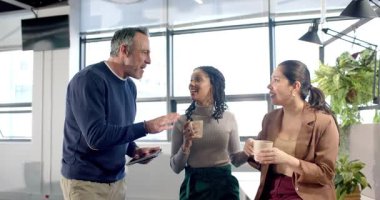 Çeşitli iş arkadaşları dinlenme odasına tabletle giren adamı dinliyor ve planlama raporlarını gözden geçiriyorlar. İşbirliği, takım çalışması, iletişim, modern, profesyonel, teknoloji, işyeri