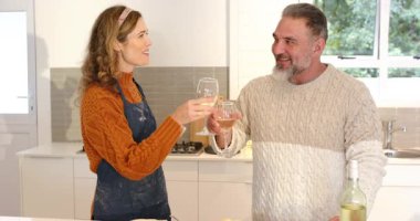 Birkaç kadın şarap kadehlerini tokuştururken mutfak adasında turta pişiriyor. Romantizm, samimiyet, kutlama, aşçılık, konfor, zarafet, yaşam tarzı