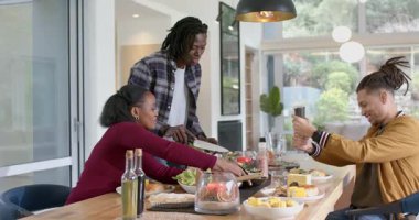 Çeşitli arkadaşlar evde toplanıyor, sebze doğruyor, salata pişiriyor ve öğle yemeği hazırlıyorlar. İşbirliği, neşe, köy, aile, tazelik, sağlıklı, açık hava