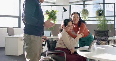 Tablet tartışmasından sonra, çeşitli iş arkadaşları tekerlekli sandalye masasında sarılıp ofiste beşlik çakıyorlardı. İşbirliği, takım çalışması, çeşitlilik, kapsama, erişilebilirlik, arkadaşlık, ofis ortamı