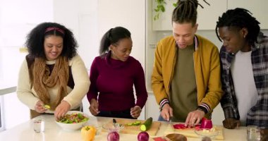 Mutfak adasında toplandıktan sonra çeşitli arkadaşlar sebze doğradılar ve kaseye salata attılar. Aşçılık, işbirliği, tazelik, takım çalışması, aşçılık, modern, canlı