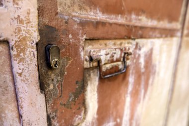 Dışarıdaki eski kilidin ayrıntıları, pas ve terk edilmişlik.