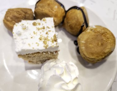 Kremalı profiterol ve çikolatalı kek, restoranda tatlı.