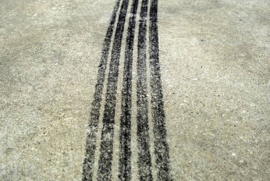 Asfaltta yanık lastik izleri var. Patinaj izi.