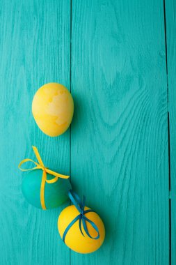 colorful easter eggs top view on blue chalkboard copy space