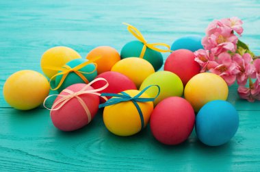 Macro Colorful Easter eggs on blue wooden kitchen table. Egg background. Selective focus
