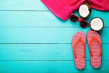 Summer accessories for modern woman on her vacation. Top view. Blue wooden background