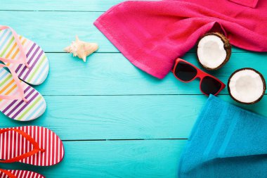Summer accessories for modern woman on her vacation. Top view. Blue wooden background