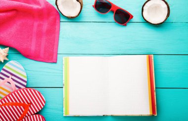 Summer accessories for modern woman on her vacation. Top view. Blue wooden background
