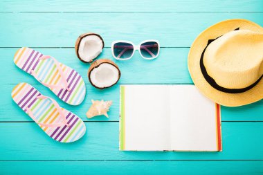 Summer accessories for modern woman on her vacation. Top view. Blue wooden background