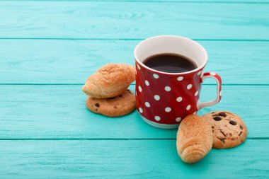 Cup of coffee with croissants on blue wooden table. Selective focus and top view