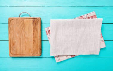 wooden empty cutting board and tablecloth on wooden background top view