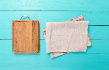 wooden empty cutting board and tablecloth on wooden background top view