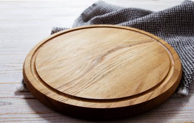empty wooden round pizza tray and tablecloth on wooden background top view
