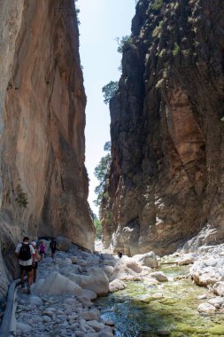 Turistler dağ geçidi boyunca yürürler seyahat ederler ve tatil yaparlar.