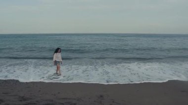 Eğrelti otlarıyla dolu bir ormanda yavaşça yürüyen bir kadın, ağır çekimde yakalandı. Huzurlu atmosfer ve yumuşak doğal ışık dinginlik, özgürlük ve eart ile bağlantı hissi yaratır.