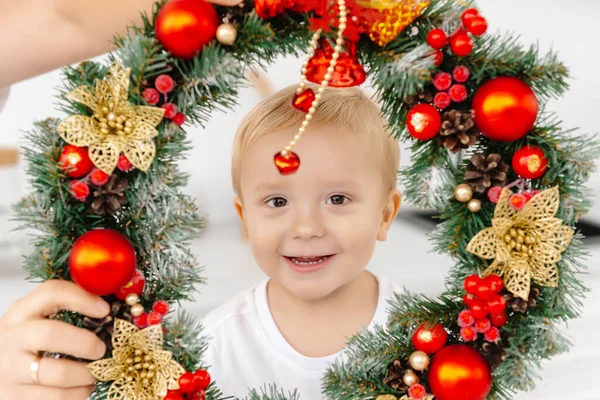 Copilul Uită Prin Coroana Crăciun Salchik Zâmbește Este Fericit Crăciun — Fotografie, imagine de stoc