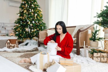 Başarısız Noel hediyesi. Kırmızı Noel kazağı giyen, hediye kutusu açık bir kadın hayal kırıklığına uğramış hissediyor..