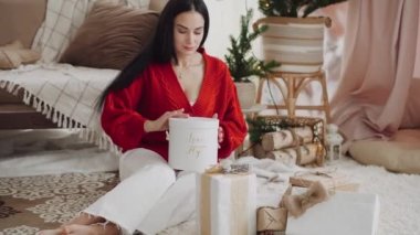 Güzel bir Noel hediyesi. Genç bir kadın Noel için bir hediye aldı ve bundan hoşlanıyor. Mutlu genç kadın Noel ve Yeni Yıl için.