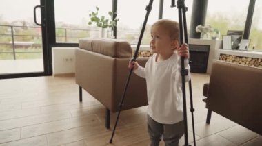 Bir çocuk blogcu elinde bir video tripod tutuyor ve genç bir blogcu olmaya hazırlanıyor