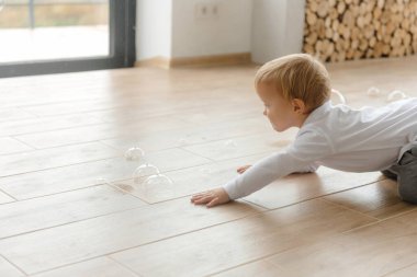 Çocuk yerde sürünüyor ve sabun köpüğü patlatıyor..