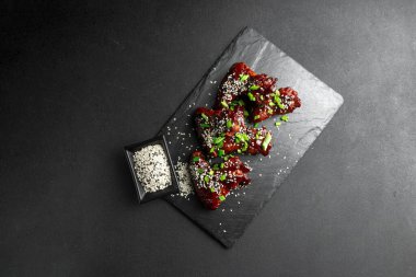 Asya yemekleri. Ev yapımı susamlı Kore usulü baharatlı tavuk kanadı. Tavuk kanadı. Geleneksel Asya tarifi. Karanlık arka plan. Üst görünüm