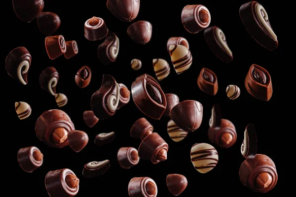 甘い茶色のチョコレートの浮遊または飛行または暗い黒の背景に混乱 — ストック写真