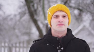 Bir kartopu bir adamın yüzüne ağır çekimde çarpar. Kış eğlencesi Aile kartopu oynuyor.