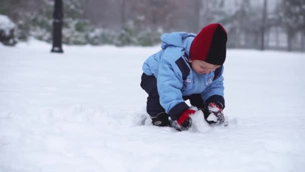 Malý Chlapec Vyřezává Velké Sněhové Koule Rukama Ulici Zimní Sezóna — Stock video