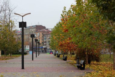 Sonbaharda fener ve banklarla dolu şehir meydanı