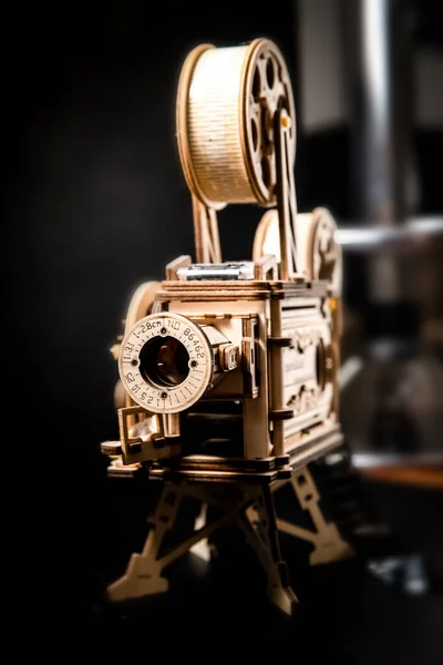 wooden model of a cinema projector, old style movie projector over dark black background. High quality photo