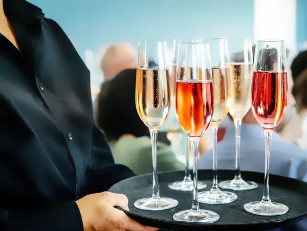 一杯红葡萄酒 由一位专业的酒席承办商提供 其背景为模糊的蓝色灰色 高质量的照片 免版税图库照片