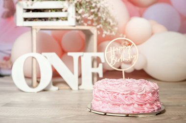 Birinci yaş günü pastası için pembe ve beyaz süsleme. Stüdyo fotoğraf çekimi. Balonlar, kağıt dekorlar, pasta ve süslemeler. Yüksek kalite fotoğraf