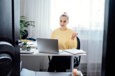 Özel ders, ev ödevi yardım ve sınav hazırlığı. Video bloğu için kameranın önünde konuşan genç bir kadın. Özel öğretmen ya da kanepe. Fazladan para kazan, para kazan.