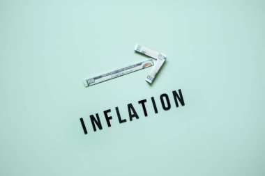 Enflasyon finansal kriz konsepti. Dolar banknotlarından oklara ve mavi arka planda enflasyona kadar büyümüş. Artan yaşam maliyeti