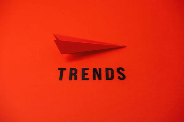 Global World Trends, Top New trends, forecasting. Word trends and red paper plane on red background