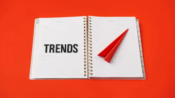 Global World Trends, Top New trends, forecasting. Word trends and red paper plane on red background